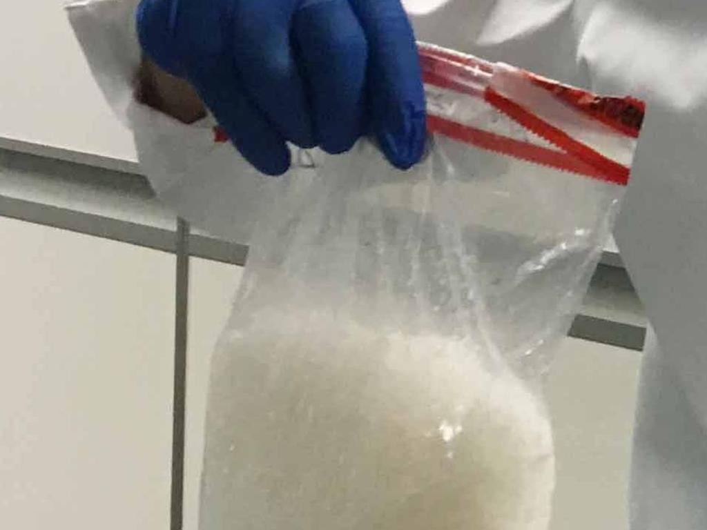 A police officer holds 1kg of ice seized in Rockhampton.