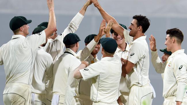 Australian fast bowler Mitchell Starc (second right) celebrates taking the wicker of Pakistan batsman Yasir Shah at the Gabba on Friday night.