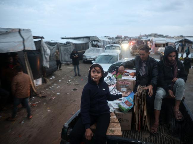 A child with a lollipop helps transport food items in the back of a small truck. Picture: AFP