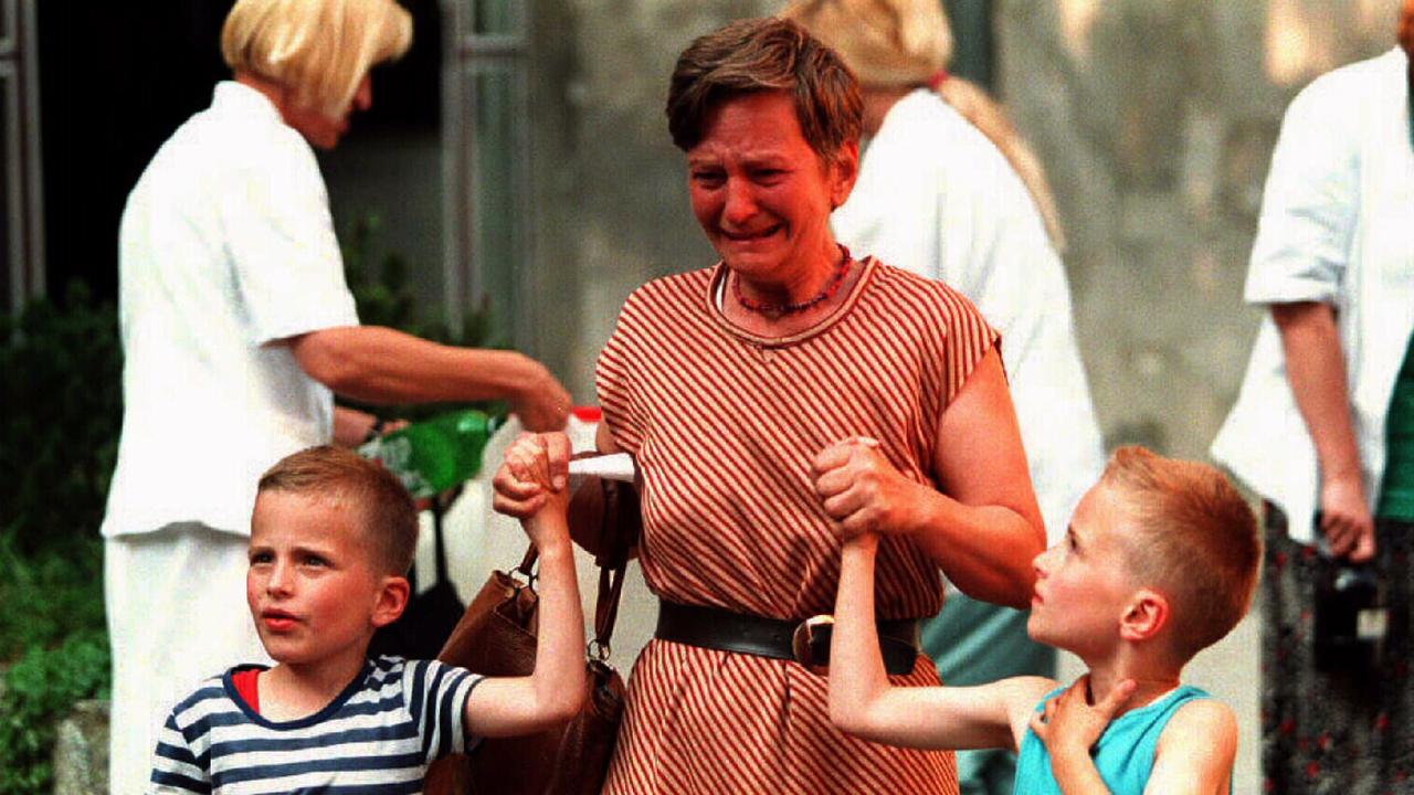 A young boy looks at his crying mother as they leave Sarajevo's Kosevo hospital after her husband was wounded by a shell in the Bosnian war.