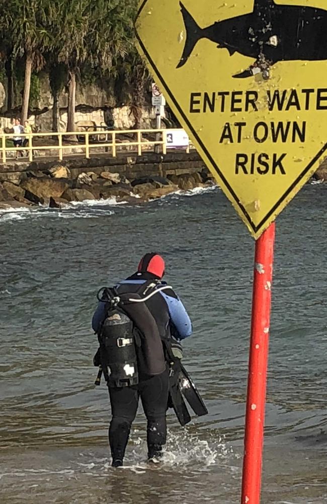 A scuba diver ignores the warning sign after Mr Schultz is bitten at Cabbage Tree Bay. Picture: Jim O'Rourke