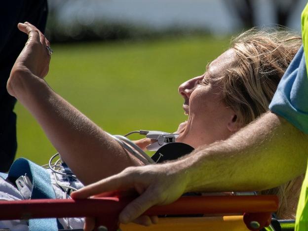 The woman tells of her affection for sharks as she is taken by stretcher to hospital in Cairns. Picture: News Corp Australia