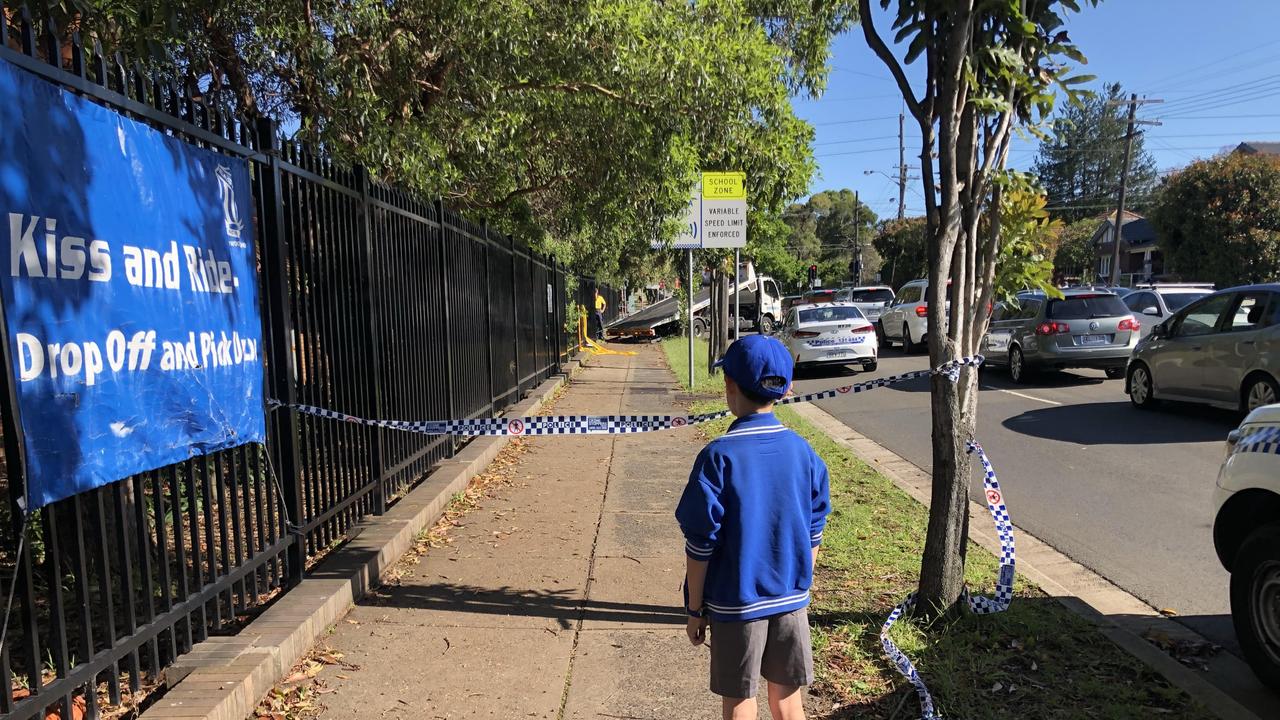 A student inspects Eastwood Public School after a car ploughed into its fence after a police chase. Picture: Gary Hamilton-Irvine