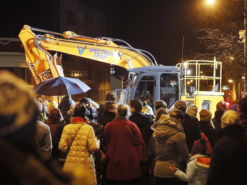 Crowds watching the excavator at work, preparing for Mike Parr's emergence from beneath Macquarie Street, Hobart, where he stayed for 72 hours as part of the Dark Mofo festival. Picture: MATHEW FARRELL