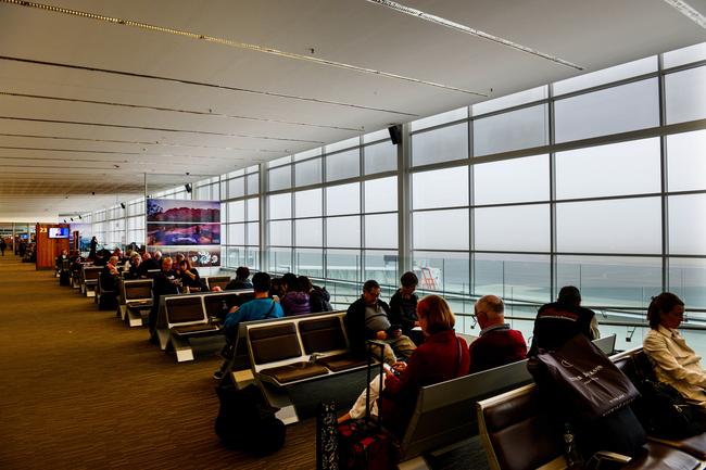 Travellers wait at Adelaide Airport for their flights to arrive. Picture: AAP / Brenton Edwards