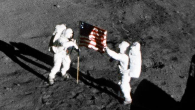 Neil Armstrong and Buzz Aldrin plant an American flag on the surface of the moon on of July 21, 1969.