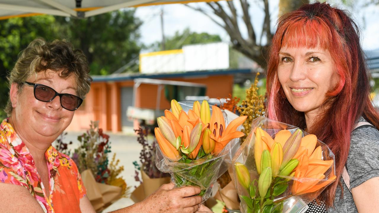 Monica Van-Den Nieuwenhof hands a bunch of home-grown flowers to Cy Stall at Lismore Farmers Markets.