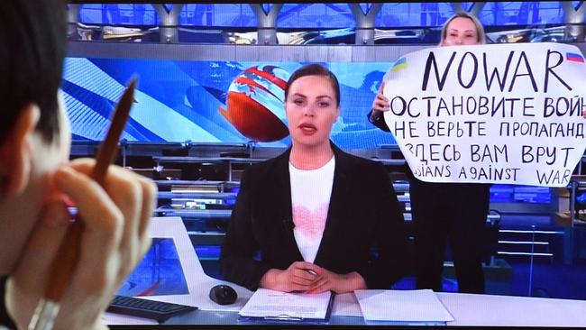 Marina Ovsyannikova holds up a handwritten poster saying "No War" in English during Russian news broadcast. Picture: AFP.