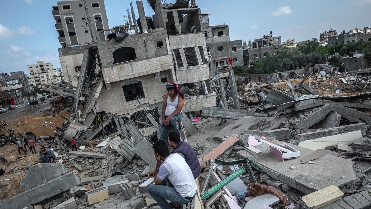 Some men sit on the rubble of a residential building in Gaza City, Gaza Strip, that was destroyed by an Israeli air strike, on May 13, 2021 in Gaza City, Gaza. Picture: Fatima Shbair/Getty Images.