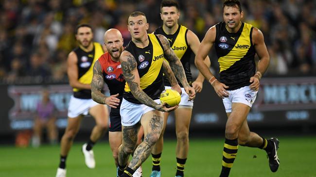 Dustin Martin looks to handpass against the Demons at the MCG last night. Picture: AAP.