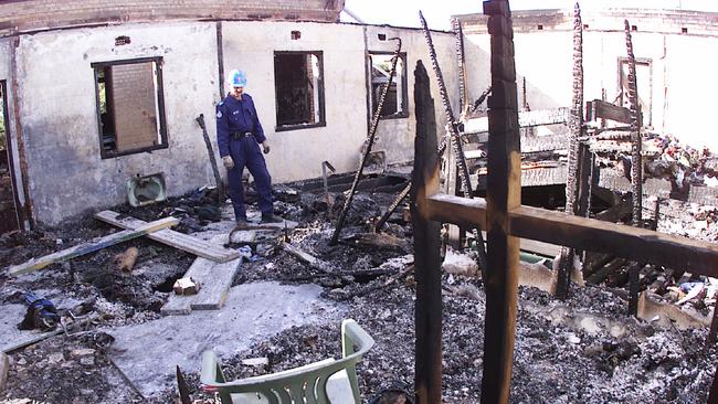 Fireman Darryl Livermore inspects remains of dormitory on upper level of Palace Backpackers Hostel in Childers following the fire that left 18 dead. Pic: Anthony Weate.