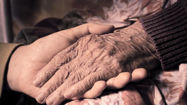 Young girl's hand touches and holds an old woman's wrinkled hands. Old age. ISTOCK