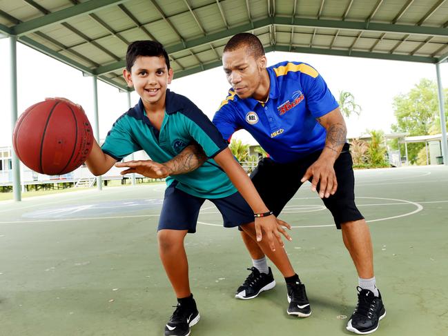 Woodroffe Primary School student Dylan Baker with Adelaide 36ers player Jerome Randle during a basketball clinic at the school.