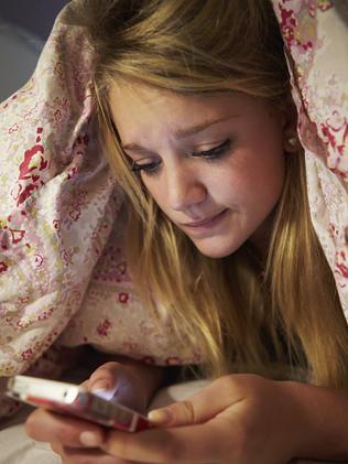 Unhappy Teenage Girl Sending Text Message Whilst Lying In Bed