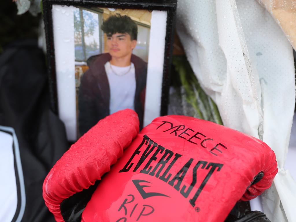 A photograph of victim Tyrese Bechard is left at the crash scene along with his boxing gloves. Picture: John Grainger