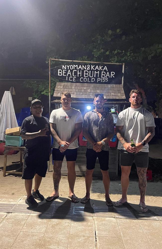 The friends posing out the front of a bar in Bali with the owner. Picture: Instagram