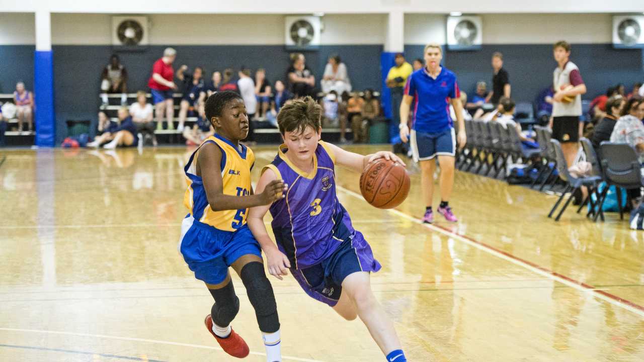 ON COURT: St Joseph's College players James Nugent (right) drives to the key during his side's Friday Night Basketball Competition match against Toowoomba Grammar School. Picture: Nev Madsen