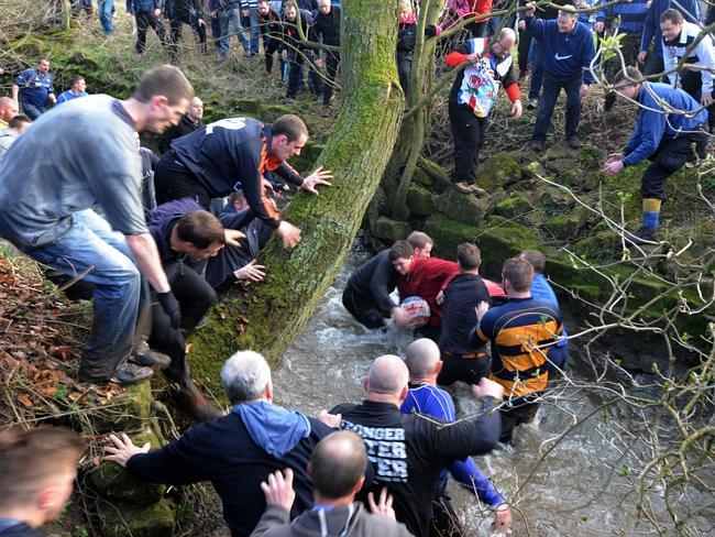 Players compete for the ball during the Royal Shrovetide Football match.