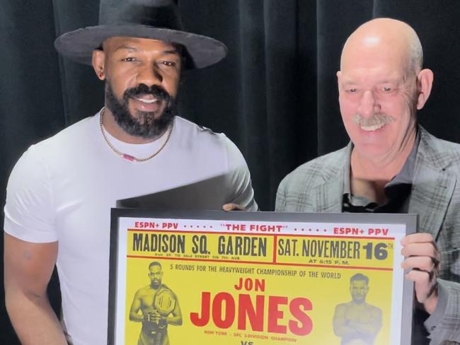 Jon Jones with Joel Fisher and the replica fight poster. Picture: Brendan Bradford