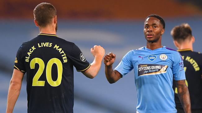 Raheem Sterling and an Arsenal player shake hands during the English Premier League football match between Manchester City and Arsenal at the Etihad Stadium on June 17, 2020. (Photo by LAURENCE GRIFFITHS / POOL / AFP)