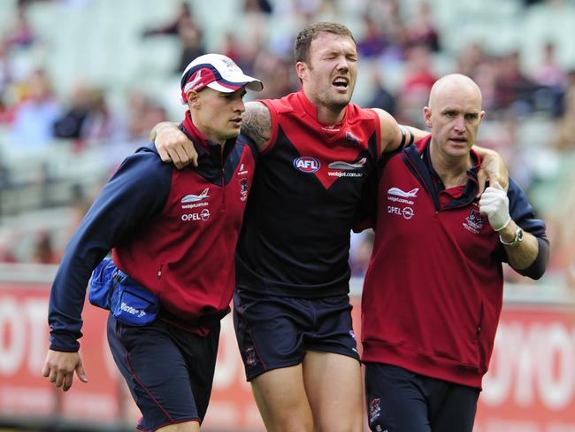 Mitch Clarke gets helped off the MCG with an injury.