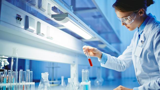 HEALTH:  Young woman working with liquids in glassware. Biotechnology research  laboratory generic