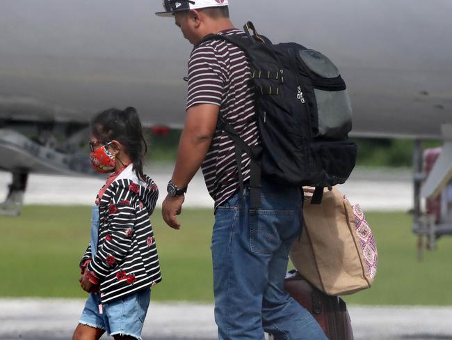 A little girl in a mask arrives at Christmas Island from Indonesia. Picture: Colin Murty