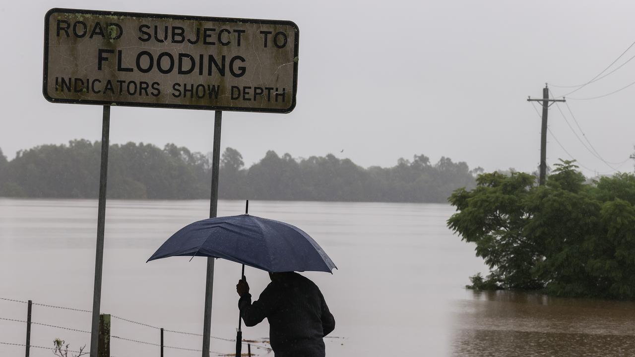 A man holds an umbrella standing next to Windsor Road in the suburb of McGraths Hill. Picture: Getty Images