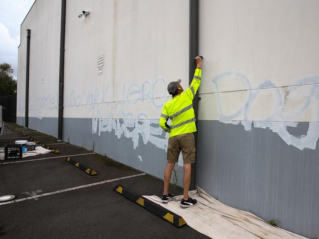 A council worker removes the graffiti on the wall of the carpark at the Mount Sinai College in Maroubra. Picture: NewsWire/ Gaye Gerard