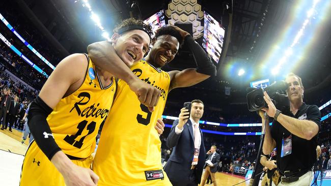 K.J. Maura and teammate Jourdan Grant of the UMBC Retrievers celebrate their 74-54 victory over Virginia.