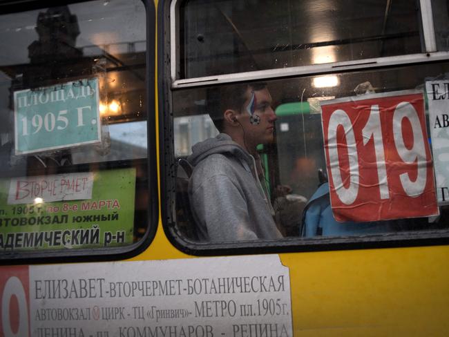 A passenger with the face paint sits in a bus in Ekaterinburg city, on June 16, 2018 during of the Russia 2018 World Cup football tournament.  / AFP PHOTO / JORGE GUERRERO