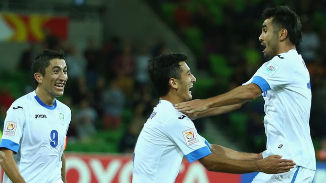 Sardor Rashidov of Uzbekistan celebrates with Jasur Khasanov and Odil Akhmedov.