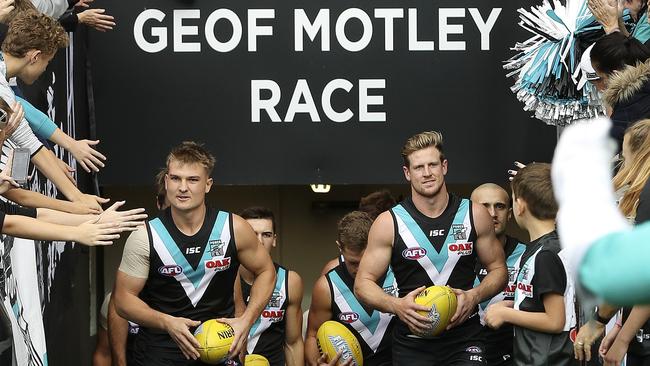 Port Adelaide’s dual captains Ollie Wines and Tom Jonas lead the team out on to Adelaide Oval. Picture SARAH REED