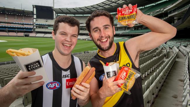 Footy fans Tim Hill and Luke Draffen with their favourite tucker at the MCG, which will increase in cost this season. Picture: Jay Town