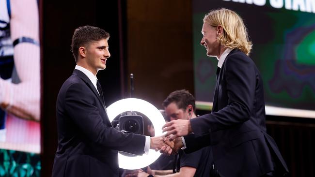 Ollie Dempsey of the Geelong Cats is presented the Rising Star by Harry Sheezel of the North Melbourne Kangaroos. Picture: Dylan Burns/AFL Photos via Getty Images