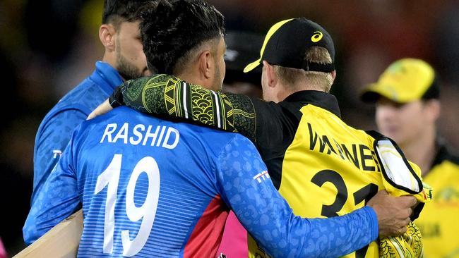 Australia's David Warner (R) embraces Afghanistan's Rashid Khan after the ICC men's Twenty20 World Cup 2022 cricket match between Australia and Afghanistan at Adelaide Oval on November 4, 2022 in Adelaide. (Photo by Brenton EDWARDS / AFP) / -- IMAGE RESTRICTED TO EDITORIAL USE - STRICTLY NO COMMERCIAL USE --