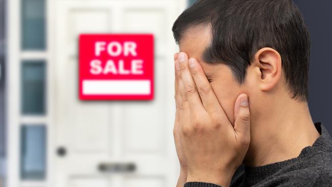 Man extremely depressed and sad about losing his house key and seeing a for sale sign, real estate concept; first home buyer generic sad, stressed