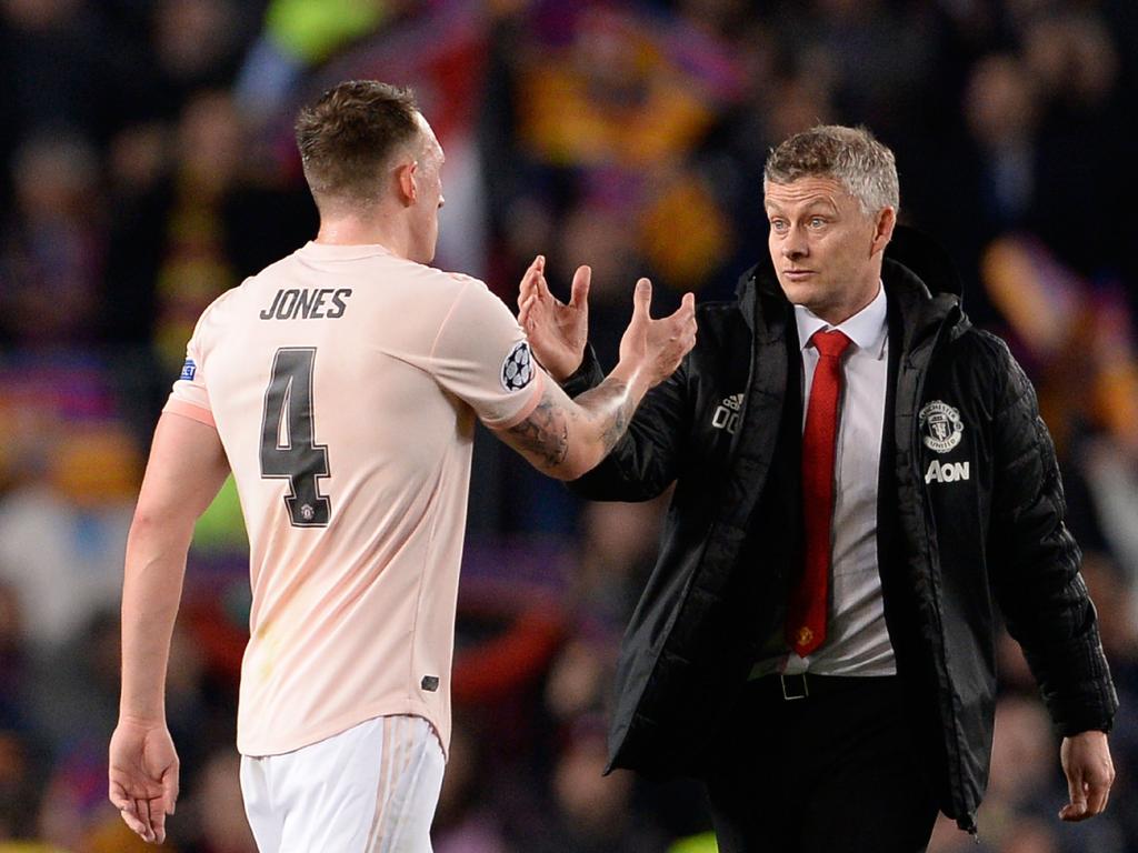 Phil Jones and coach Ole Gunnar Solskjaer. (Photo by PAU BARRENA / AFP)