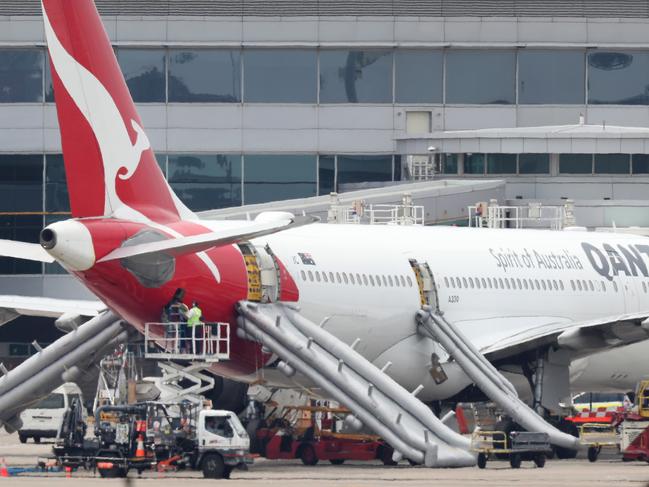 Workers inspecting QF575 at the Sydney Domestic Airport Terminal 3. Picture: Jonathan Ng