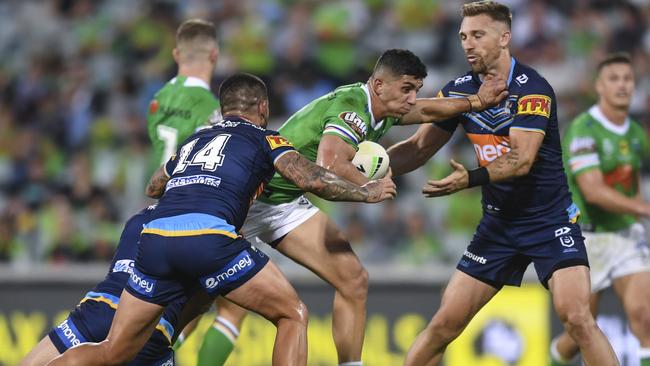 Emre Guler of the Raiders (centre) is tackled by Nathan Peats of the Titans during the Round One NRL match between Canberra Raiders and Gold Coast Titans at GIO Stadium in Canberra, Friday, March 13, 2020. (AAP Image/Lukas Coch) NO ARCHIVING, EDITORIAL USE ONLY