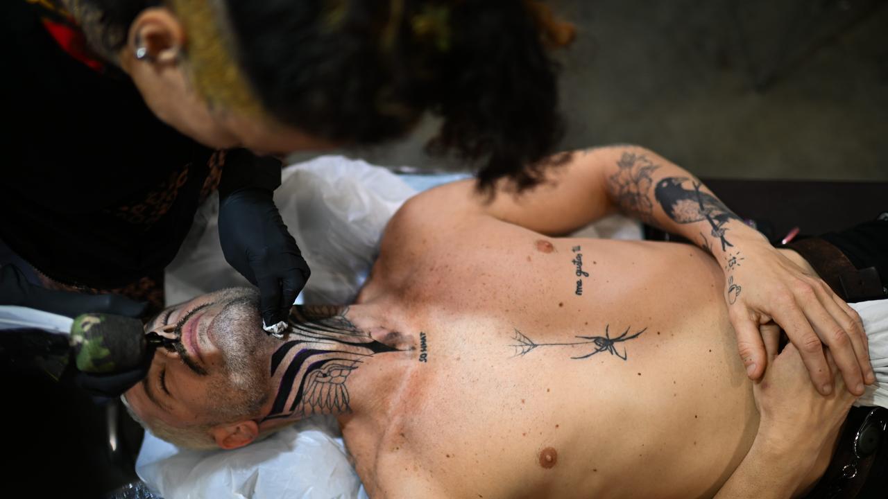 A tattoo enthusiast receives a fresh neck tattoo at the Australian Tattoo Expo in Brisbane. Picture: Dan Peled / NewsWire