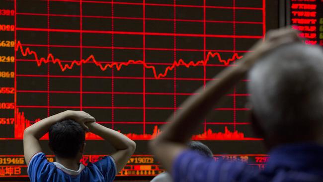 FILE - In this Monday, Aug. 31, 2015, file photo, investors monitor a display showing the Shanghai Composite Index at a brokerage in Beijing. From Australia to Zambia, Chile to Indonesia, the pain of China’s sharp economic slowdown is being felt in the form of depressed commodity prices, elevated unemployment and shrunken home prices. (AP Photo/Ng Han Guan, File)