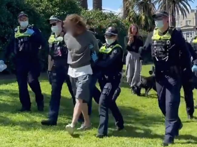 Officers placed a man in handcuffs as they led him away from Luna Park. Picture: Olivia Jenkins