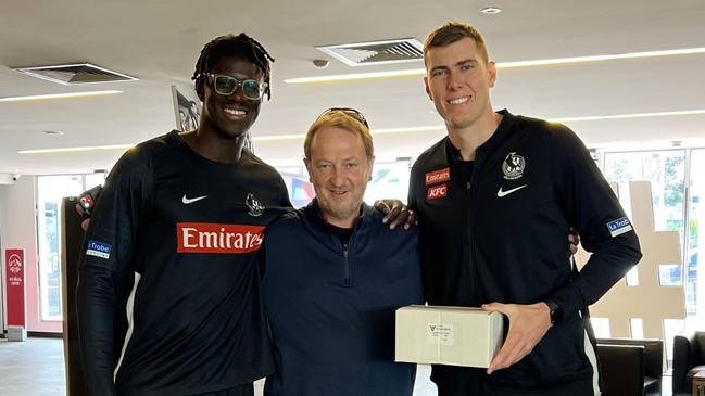 Collingwood international rookie Bassirou Faye, optometrist John Carbury and Magpies star Mason Cox pictured at Collingwood with their prescription glasses.