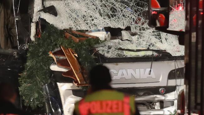 BERLIN, GERMANY - DECEMBER 19: Police stand near a black lorry that ploughed through a Christmas market on December 19, 2016 in Berlin, Germany. At least nine people have died as police investigate the attack and whether it is linked to a terrorist plot. (Photo by Sean Gallup/Getty Images)