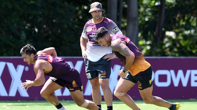 Brisbane Broncos players Darius Boyd (right) and Kodi Nikorima run past head coach Anthony Seibold during training in Brisbane. Picture: Dan Peled.