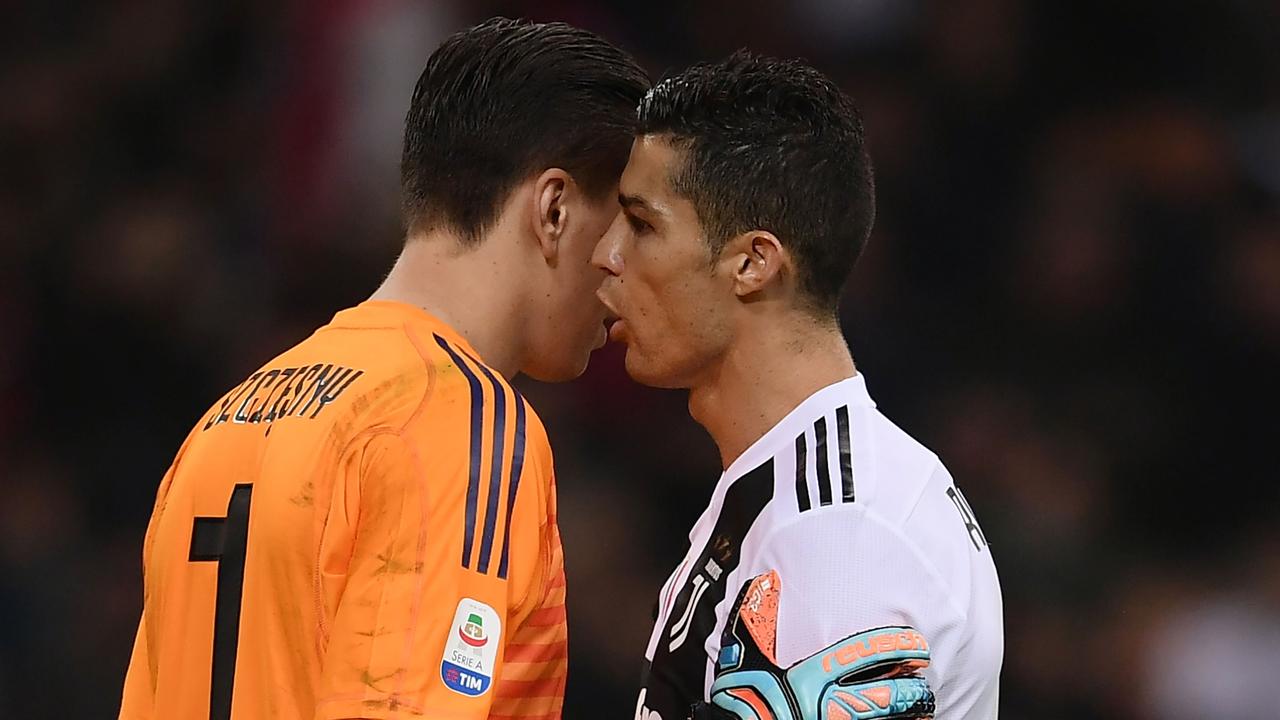 Ronaldo speaks to Wojciech Szczesny. (Photo by Marco BERTORELLO / AFP)