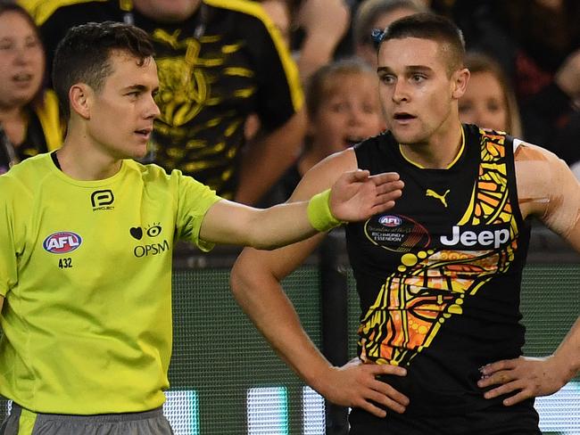 Jayden Short of the Tigers (right) and umpire Curtis DeBoy are seen after the Bombers were awarded a deliberate rushed behind during the Round 10 AFL match between the Richmond Tigers and the Essendon Bombers at the MCG in Melbourne, Saturday, May 27, 2017. (AAP Image/Julian Smith) NO ARCHIVING, EDITORIAL USE ONLY