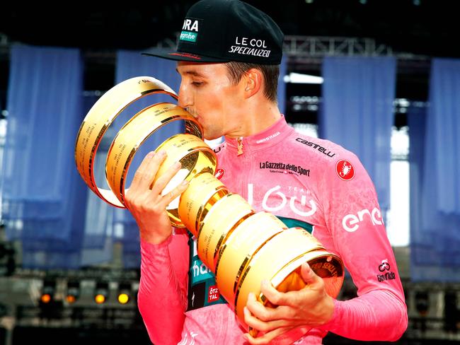 TOPSHOT - Team Bora's Australian rider Jai Hindley celebrates kisses the "Trofeo Senza Fine" race winner's trophy on the podium after winning the Giro dâItalia 2022 cycling race, following the last stage, a 17.4 km individual time trial in Verona on May 29, 2022. (Photo by Luca Bettini / AFP)