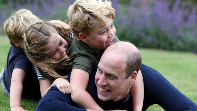 William plays with his children, from left, Louis, Charlotte and George. Picture: Alphapress / Australscope